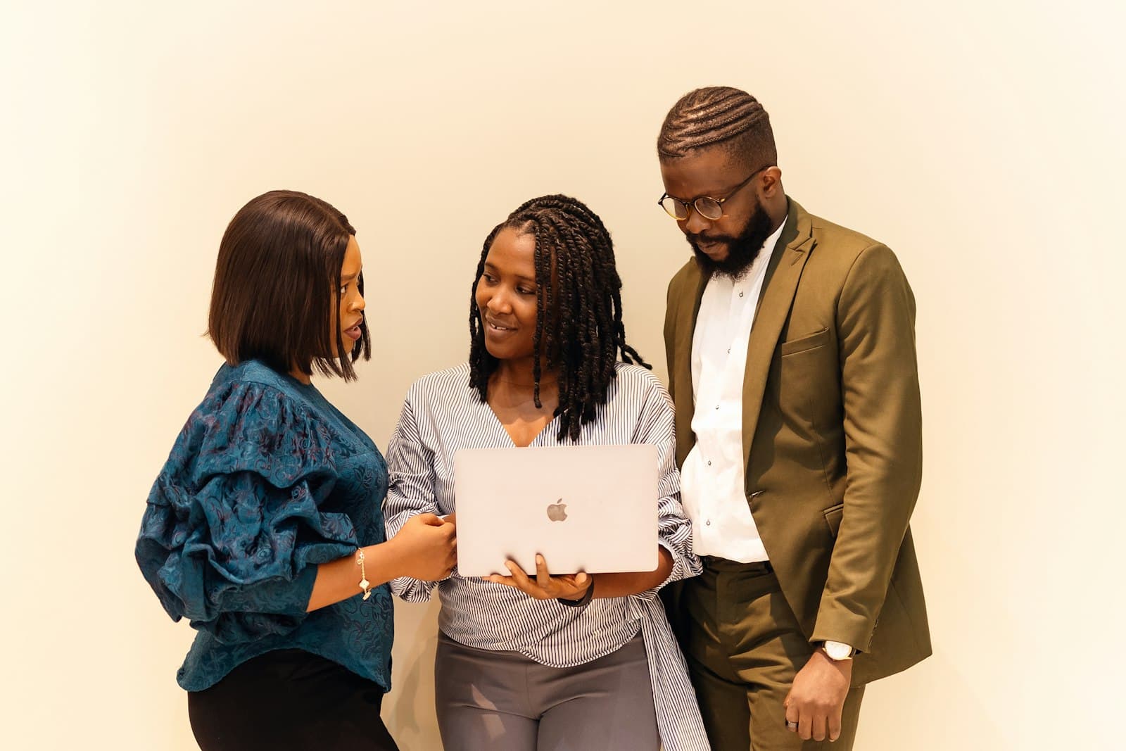 Three colleagues discussing a project around a laptop